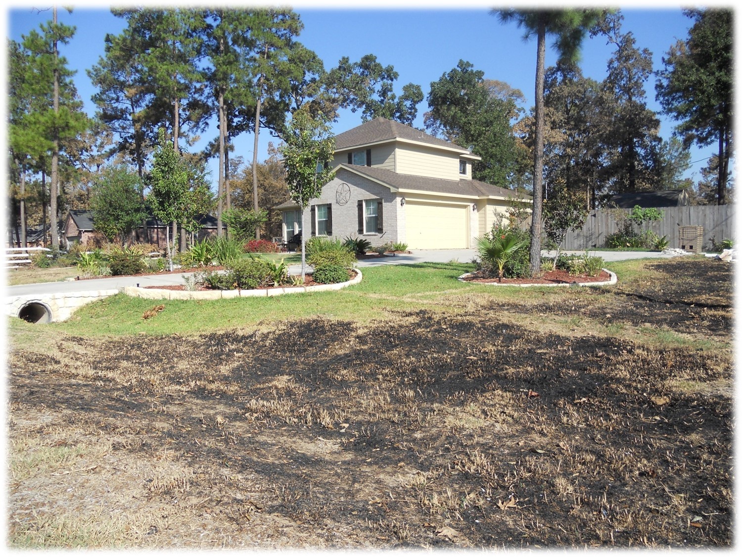 BURNT GRASS LEADING UP TO NON-COMBUSTIBLE LANDSCAPING